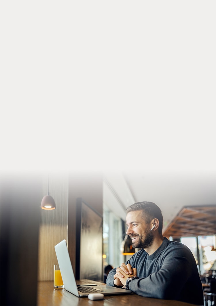 Man laughing while looking at laptop
